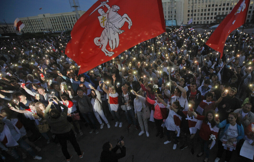 Demonstranter vifter med det gamle flagget med den hvite rytteren «Pahonia» framfor regjeringsbygningen i Minsk tidligere i august. Foto: Dmitri Lovetsky/NTB scanpixA/AP.