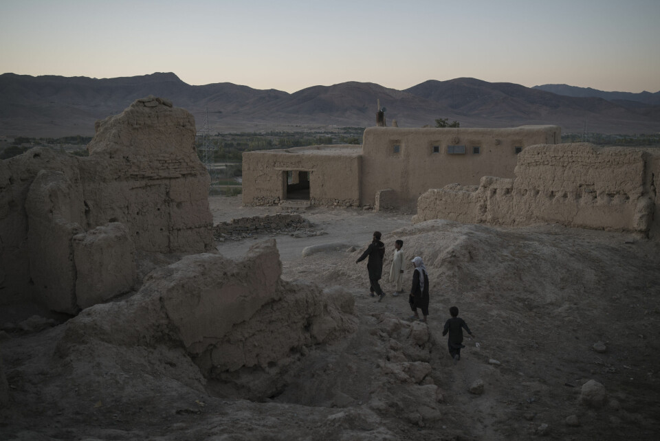 RUINER: De går i ruinene av hus som er ødelagt i krigen. Bildet er fra Wardak-provinsen. I flere regioner i Afghanistan er det nå sult og nød. Afghans walk among the rubble of houses destroyed by fighting at a village in Wardak province, Afghanistan, Tuesday, Oct. 12, 2021. (AP Photo/Felipe Dana)