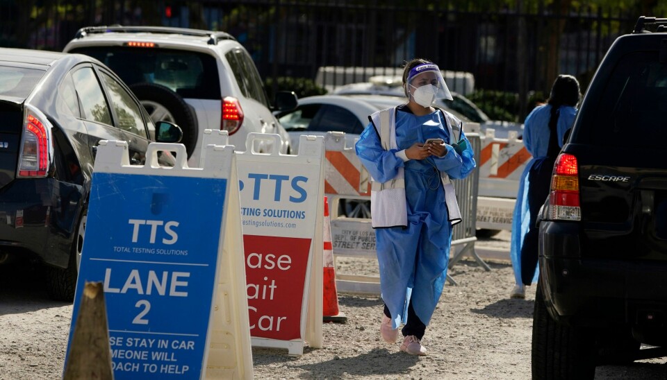 TESTER: Helsearbeidere i fullt utstyr ved et testsenter i Los Angeles. Helsearbeidere i fullt utstyr ved et testsenter i Los Angeles. Foto: Marcio Jose Sanchez / AP / NTB