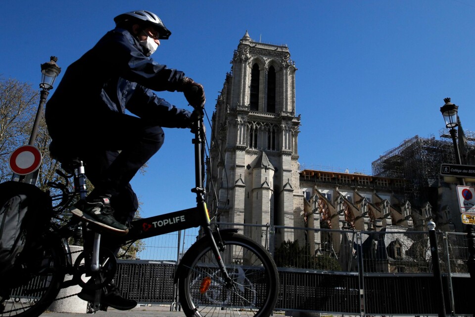 A man wearing a face mask rides his bike in front of Notre Dame cathedral during a nationwide confinement to counter the Covid-19, in Paris, Sunday, April 5, 2020. The new coronavirus causes mild or moderate symptoms for most people, but for some, especially older adults and people with existing health problems, it can cause more severe illness or death. (AP Photo/Christophe Ena) A man wearing a face mask rides his bike in front of Notre Dame cathedral during a nationwide confinement to counter the Covid-19, in Paris, Sunday, April 5, 2020. The new coronavirus causes mild or moderate symptoms for most people, but for some, especially older adults and people with existing health problems, it can cause more severe illness or death. (AP Photo/Christophe Ena)