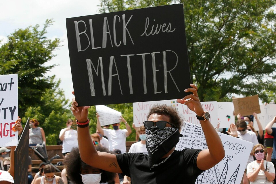 FILE - In this June 1, 2020, file photo, Atlanta Hawks guard Trae Young holds a 'Black Lives Matter' sign during a peaceful rally in his hometown of Norman, Okla., calling attention to the killing of George Floyd. While NBA players are using the season restart to demand change; coaches in the league are not making them walk down that path alone. (AP Photo/Sue Ogrocki, File)