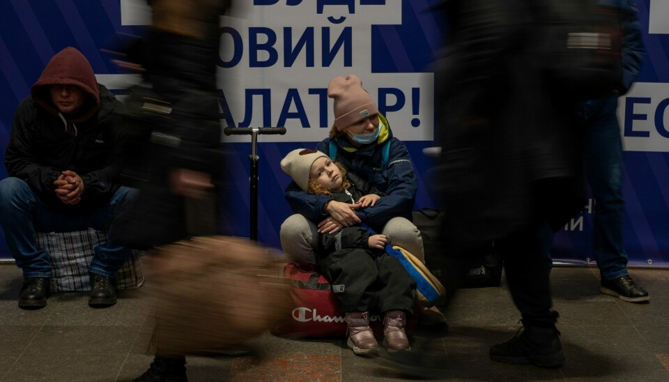 VEKK: En mor og datter venter på et tog på jernbanestasjonen i Kyiv torsdag. Befolkningen i hovedstaden våknet av eksplosjoner grytidlig om morgenen. En kvinne venter, sammen med datteren på togstasjonen i Kyiv. Mange søkte også tilflukt på t-banestasjoner torsdag