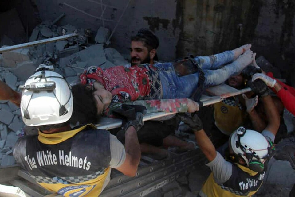 En jente blir båret ut etter et luftangrep i en nordlig by i Idlin-provinsen, Syria.