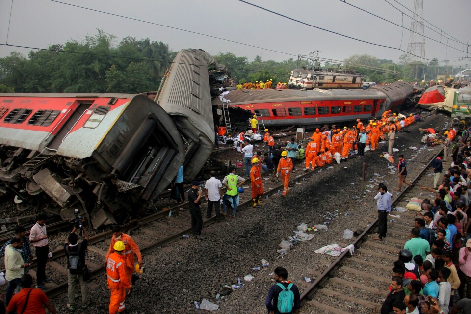 Redningsarbeidere på stedet der to tog var involvert i en massiv avsporing og kollisjon i den østlige delstaten Odisha i India lørdag. Foto: AP/NTB Redningsarbeidere på stedet der to tog var involvert i en massiv avsporing og kollisjon i den østlige delstaten Odisha i India lørdag. Foto: AP/NTB