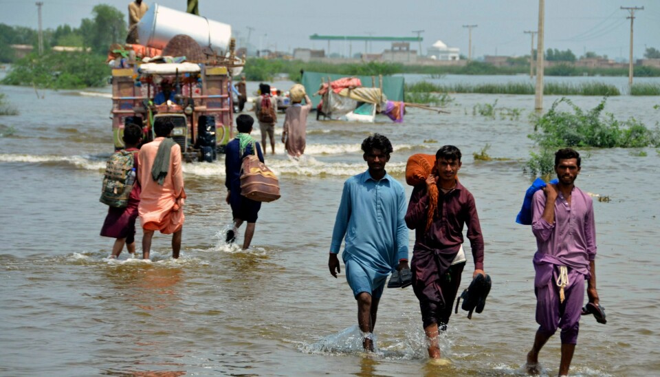 Pakistanere vasser gjennom oversvømte områder i Balutsjistan-provinsen sørvest i Pakistan. Pakistanere vasser gjennom oversvømte områder i Balutsjistan-provinsen sørvest i Pakistan. Foto: Zahid Hussain / AP / NTB