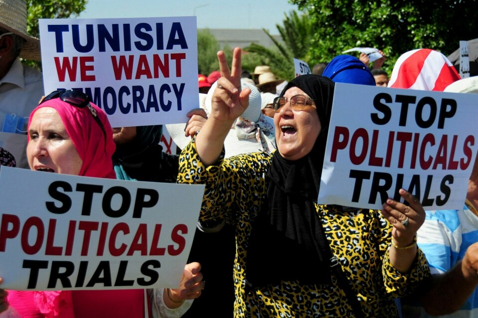 OPPOSISJONEN: Støttespillere til lederen av Ennahda-partiet, Rachid Ghannouchi, holder opp plakater under en demonstrasjon i Tunis 19. juli. Støttespillere til lederen av Ennahda-partiet, Rachid Ghannouchi, holder opp plakater under en demonstrasjon i Tunis 19. juli. Foto: Hassene Dridi / AP / NTB