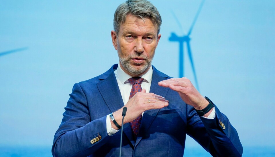 NORGE: Olje- og energiminister Terje Aasland (Ap) under en pressekonferanse om havvind i Marmorhallen i Oslo. Bildet er av olje- og energiminister Terje Aasland. Han holder hendene opp foran seg, den ene litt høyere enn den andre. De er vannrett. I bakgrunnen er det en skjerm der det er bilde av en vindmølle. Foto: Lise Åserud / NTB