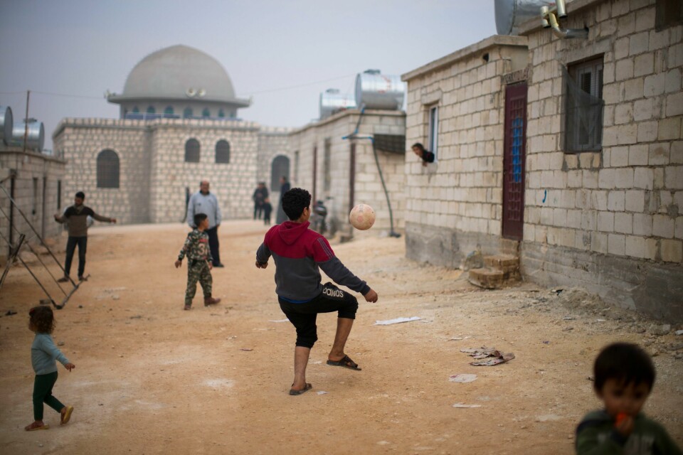 SYRIA: Syriske barn leker i Sarmada-området, nord for byen Idlib i Syria. Syria var det landet som i 2021 fikk flest bistandskroner fra Norge. Syrian children play with a ball in a refugee camp for displaced people run by the Turkish Red Crescent in Sarmada district, north of Idlib city, Syria, Friday, Nov. 26, 2021. Fallout from the 2-month-old war in Ukraine is worsening long-term humanitarian crises elsewhere, including in Syria. (AP Photo/Francisco Seco)