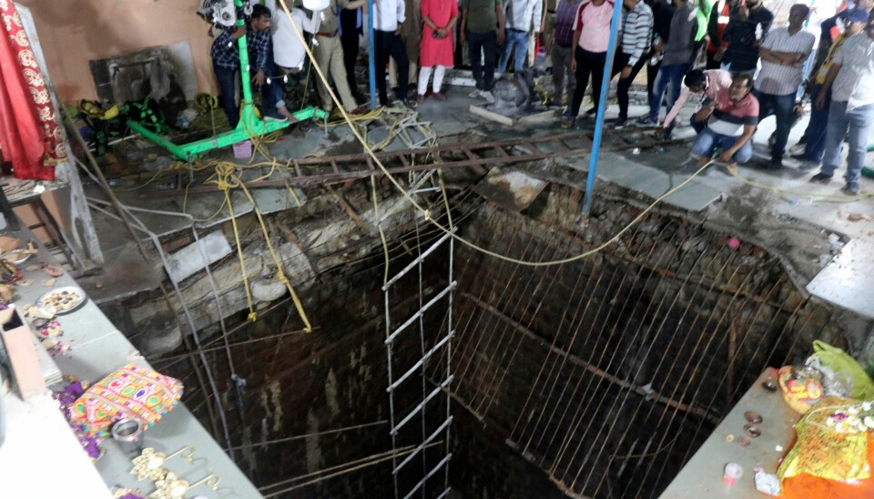 Bildet viser det kollapsede gulvet som var bygget over en gammel brønn i et tempel der mange hinduister var samlet i Indore i India torsdag. Bildet viser det kollapsede gulvet som var bygget over en gammel brønn i et tempel der mange hinduister var samlet i Indore i India torsdag. AP / NTB