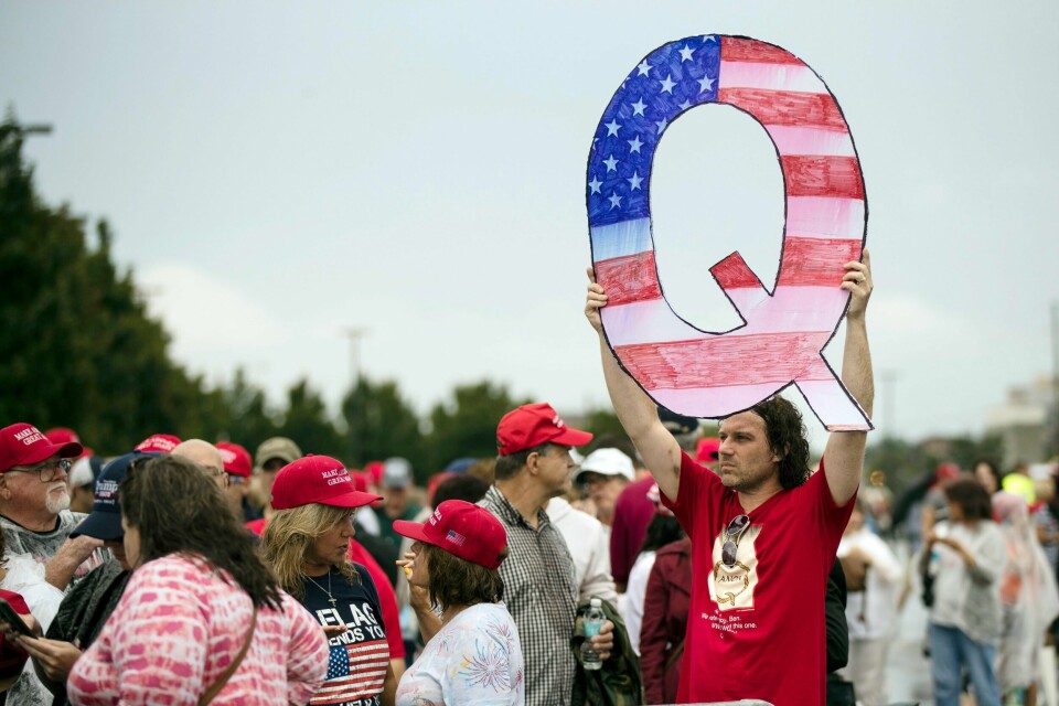 I dette bildet fra august 2018 ser man en mann holde et skilt av bokstaven «Q» utenfor et valgkampmøte for president Donald Trump i Wilkes-Barre. Bokstaven står for konspirasjonsteorien Qanon. I dag er det flere amerikanere som støtter Qanon som prøver å bli valgt inn i den lovgivende forsamlingen i USA (AP Photo/Matt Rourke).