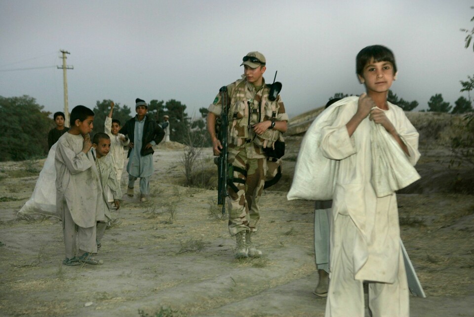 HJELPERE: De norske soldatene som var i Afganistan fra 2011 til 2021 hadde mange afghanske hjelpere, særlig tolker som ble brukt på oppdragene utenfor leir - her fra Meymaneh, en soldat på patrulje. Over 9.000 nordmenn har tjenestegjort i Nato-styrken i Afghanistan, og ti norske soldater har mistet livet under tjeneste i landet. Dette bildet er fra Maimana i 2006. Foto: Heiko Junge / NTB.
