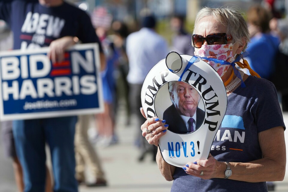 A Democratic supporter holds a bed pan with 'Dump Trump' on it, Tuesday, Nov. 3, 2020, in Omaha, Neb. (AP Photo/Nati Harnik)
