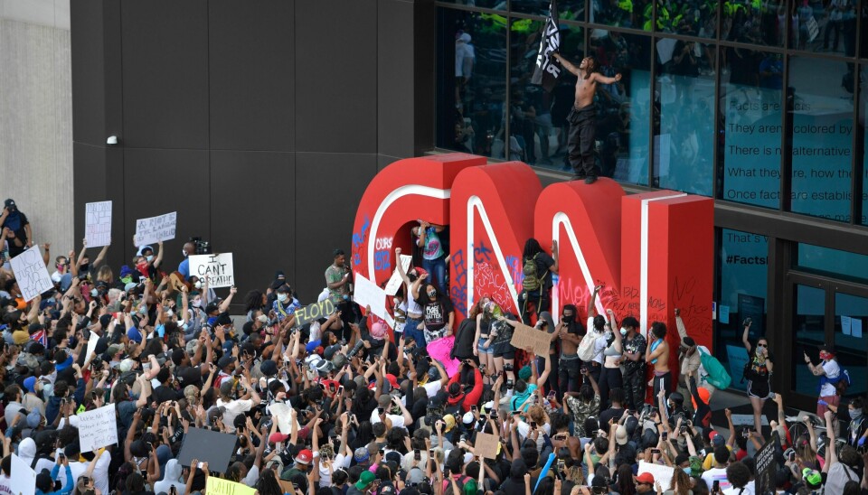 Demonstranter maler slagord på og ramponerer CNN-logoen utenfor kabelselskapets hovedkvarter i Atalanta tidligere i år. Kanalen blir sett på som en politisk aktør, og er ikke alene om det.