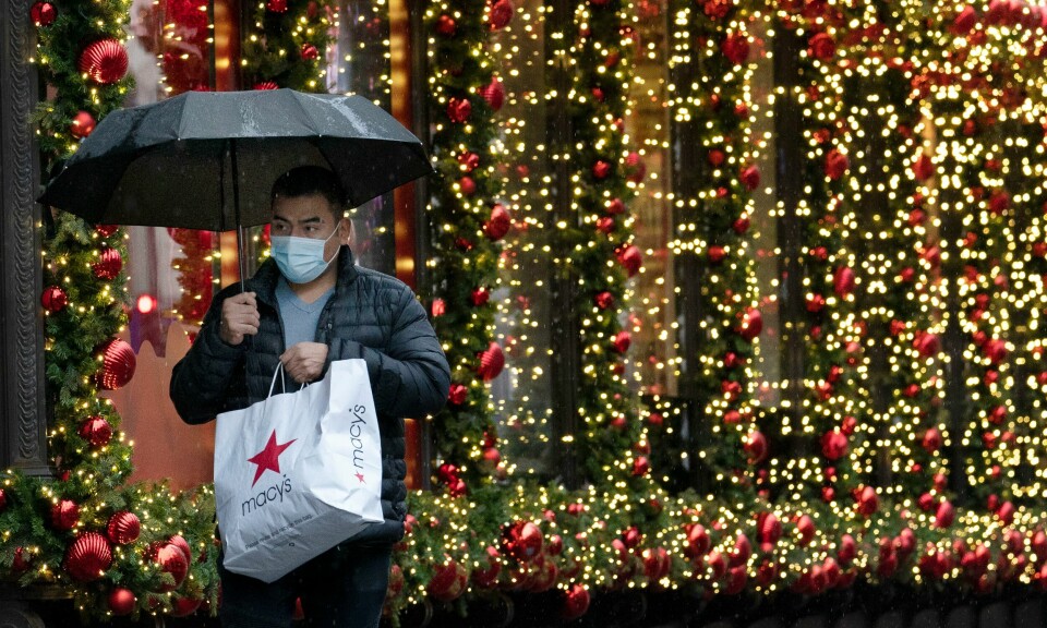 En mann i New York gjør unna julehandelen med munnbind. Foto: Mark Lennihan / AP / NTB