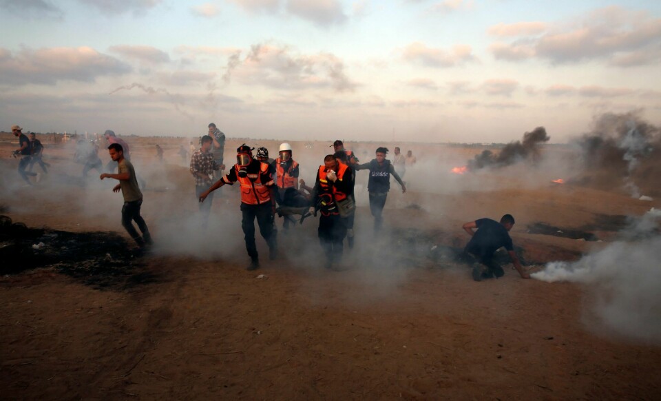 De palestinske protestene på Gazastripen fortsetter, i regi av den militante islamististgruppen Hamas. Her får demonstranter hjelp til å komme seg unna tåregass avfyrt fra israelske styrker fredag.