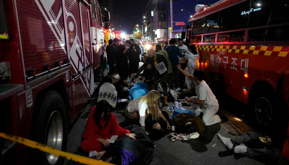 Skadde mennesker får hjelp i en av gatene i Seoul. Et stort antall mennesker har mistet livet eller er skadd i trengselen som oppsto under halloween-feiring byen. Foto: AP / NTB Skadde mennesker får hjelp i en av gatene i Seoul. Mange er Injuried people are helped at the street near the scene in Seoul, South Korea, early Sunday, Oct. 30, 2022. South Korean officials said around 50 people were in cardiac arrest and a number feared dead after being crushed by a large crowd pushing forward on a narrow street during Halloween festivities in the capital Seoul. (AP Photo/Lee Jin-man)