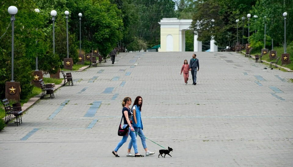 Ukrainske innbyggere i russisk-okkuperte Kherson i mai. Mens russiske myndigheter sier at titusener av sivile er evakuert fra byen, mener ukrainske myndigheter at mange av dem er tvangsdeportert. Lokale innbyggere ved minnesmerket for kampen mot nazistene i Kherson 20. mai. Foto: AP / NTB