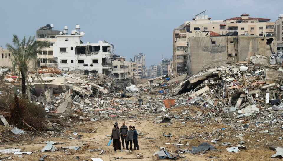 GAZA: Palestinere foran bygninger ødelagt i israelske angrep i Gaza by. Human Rights Watch mener Israel gjør seg skyldig i krigsforbrytelser på Gazastripen. Palestinere står ved bygninger som har blitt ødelagt i israelske luftangrep i Gaza by. Foto: Mohammed Hajjar / AP / NTB