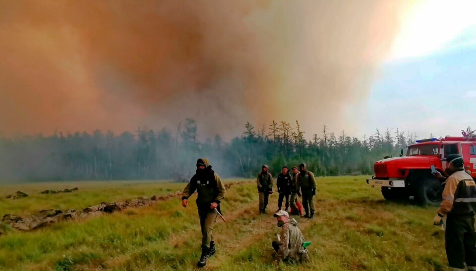 KJEMPER MOT BRANNENE: Brannmannskaper prøver å stanse skogbranner i området Gorny Ulus vest i republikken Jakutia/Sakha i Russland i helgen. Da var det 93 aktive skogbranner over enorme områder i republikken. Firefighters gather as they work at the scene of forest fire at Gorny Ulus area west of Yakutsk, in Russia, Saturday, Aug. 7, 2021. Wildfires in Russia's vast Siberia region endangered several villages Saturday and prompted authorities to evacuate residents of some areas. In northeastern Siberia, 93 active forest fires burned across 1.1 million hectares (2.8 million acres) of Sakha-Yakutia, officials said, making it the worst affected region of Russia. (AP Photo/Ivan Nikiforov)