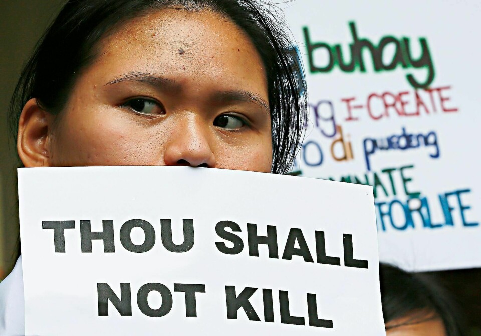 En filippinsk kvinne demonstrerer med ett av De ti bud mot landets president Rodrigo Duterte. Ifølge Amnesty har Dutertes krig mot narkotika allerede krevd livene til flere titalls barn, og nå ønsker presidenten også å kunne fengsle barn helt ned i 12-årsalderen.