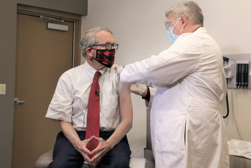 STIKK: Guvernør Mike DeWine i Ohio fikk vaksinen i februar. Nå har han sagt at alle som tar vaksinen kan være med i et lotteri, der fem personer kan vinne en million dollar hver. FILE - In this Tuesday, Feb. 2, 2021 photo provided by the Ohio Governor's Office, Gov. Mike DeWine, left, gets his first dose of the COVID-19 vaccine from Dr. Kevin Sharrett, in Jamestown, Ohio. On Friday, April 9, 2021, The Associated Press reported on stories circulating online incorrectly asserting masks are no longer mandatory in Ohio, and DeWine isnt saying a word about it. But masks remain mandatory in Ohio in indoor spaces as well as outdoors when social distancing is not possible. Ohio rescinded its previous coronavirus health orders on April 5, but the state issued a new order the same day simplifying the guidelines. (Ohio Governor's Office via AP)
