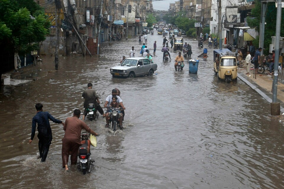 Mennesker vasser gjennom gatene i forretningsdistriktet i Karachi i Pakistan 9. juli. Mennesker vasser gjennom gatene i forretningsdistriktet i Karachi i Pakistan 9. juli. Foto: Fareed Khan / AP / NTB