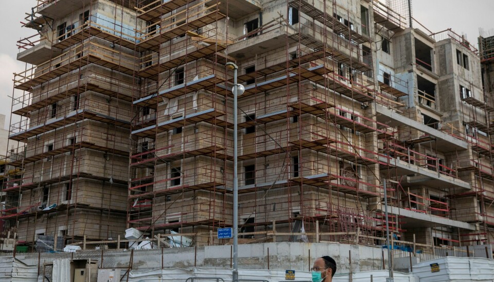 BOSETTINGER: Israelske bosettinger i Øst-Jerusalem var kjernen i den siste konflikten mellom Israel og Palestina tidligere i år. Israels nye regjering vil utvide flere bosetninger. An Ultra-orthodox Jewish man walks past a construction site of new residential project in the east Jerusalem settlement of Ramat Shlomo Tuesday, Nov. 10, 2020. Israel's West Bank settlements could provide a key test case for U.S.-Israel relations during the Biden presidency. Israel has an opportunity to push through a final frenzy of construction plans during the last two months of the settlement-friendly Trump administration. But doing so would risk antagonizing the incoming president, who has a long history of opposition to Israeli construction in the occupied West Bank. (AP Photo/Ariel Schalit)