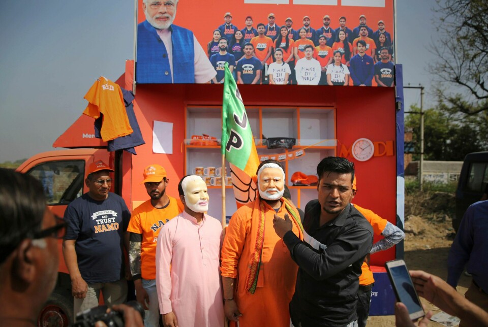 Tilhengere av Indias statsminister Narendra Modi går med masker av ansiktet hans. Modi er favoritt til å vinne valget som avsluttes i mai.
