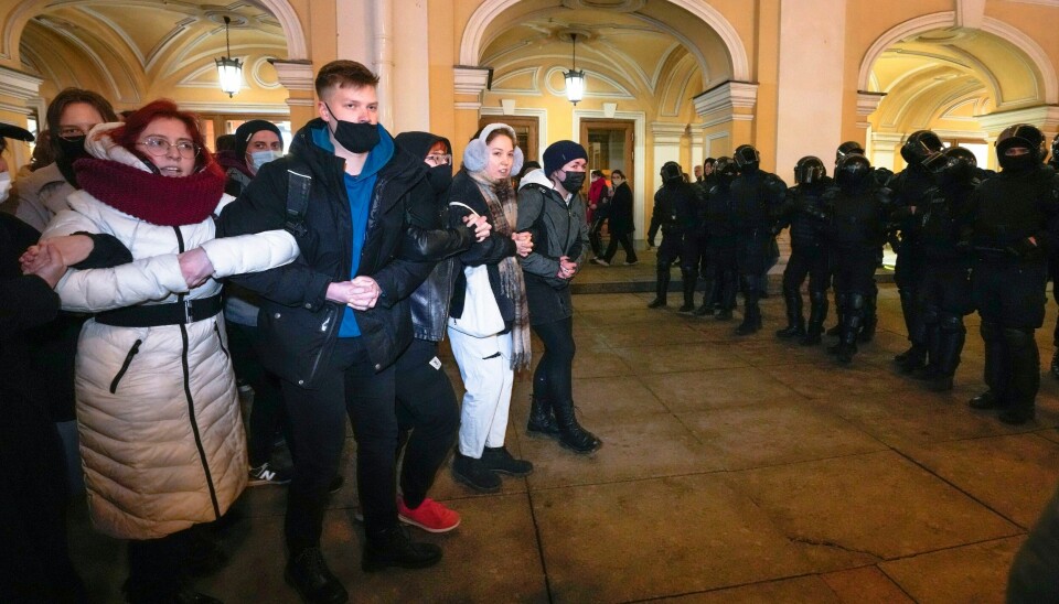 Russere demonstrerer mot krigen i St. Petersburg tirsdag 1. mars. Polititet står klar til å gripe inn. Protester i Russland