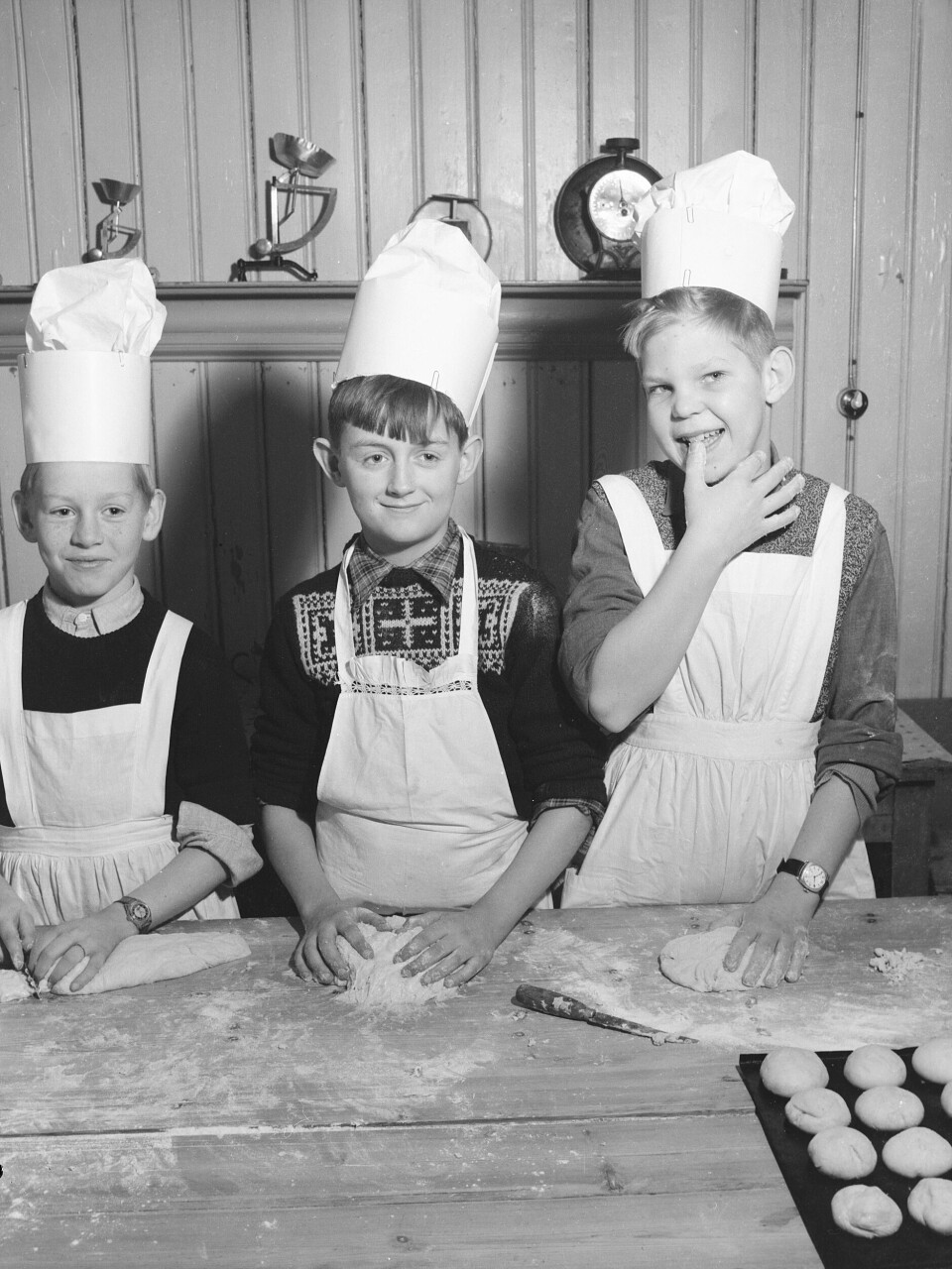 Bollebaking på skolekjøkkenet ved Nesheim privatskole i Oslo i 1946. Den elektriske komfyren hadde fått fotfeste i mellomkrigstiden, og med etterkrigstidens fryseboks lå forholdene godt til rette for hjemmebakst av typen småboller. Foto: Scanpix