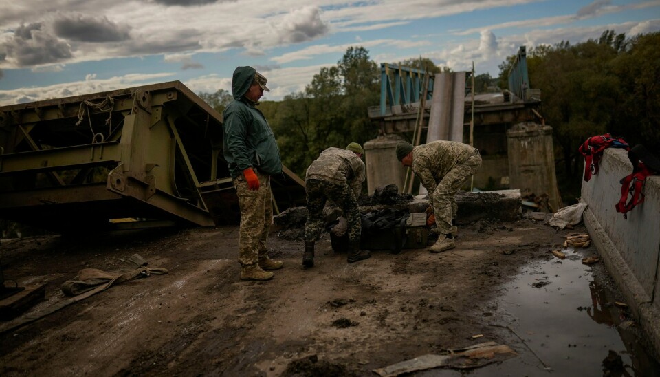 KJEMPER: Ukrainske soldater fjerner metallbiter mens de jobber på ei bru som ble ødelagt under kampene med russiske soldater i Izium øst i Ukraina. Ukrainske soldater fjerner metallbiter mens de jobber på ei bru som ble ødelagt under kampene med russiske soldater i Izium øst i Ukraina. Foto: Francisco Seco / AP / NTB