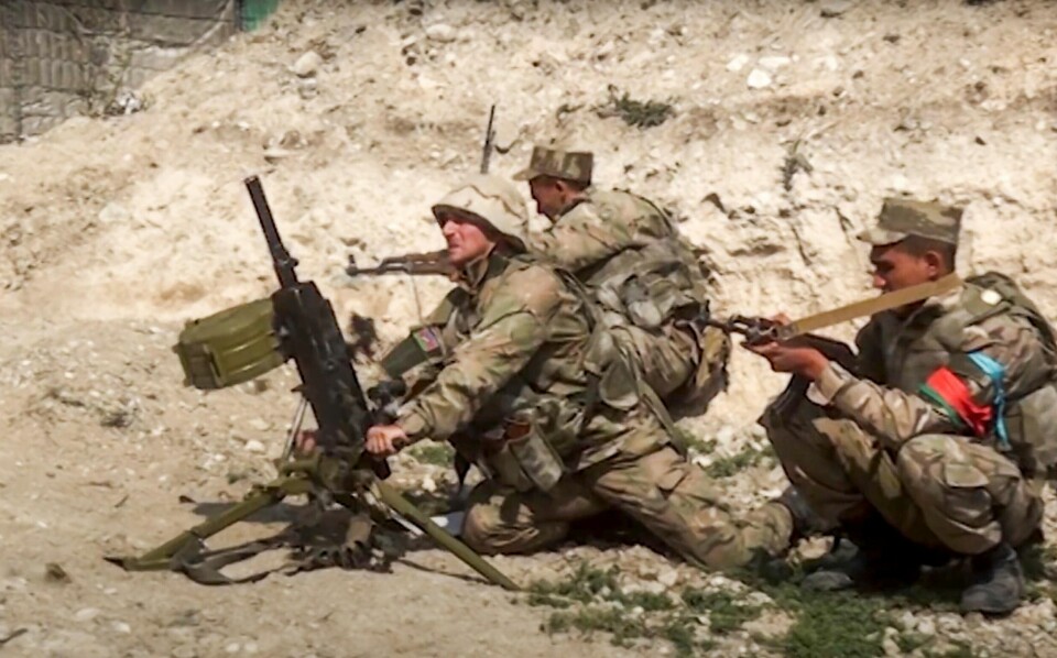 I dette bildet tatt fra opptak fra Aserbadsjans forsvarsdepartement søndag 27. september, ser man landets soldater i aksjon på grensen til den den selvproklamerte Republikken Nagorno-Karabakh. Armenske og aserbajdsjanske styrker skylder på hverandre for angrepene. (Azerbaijan's Defense Ministry via AP).