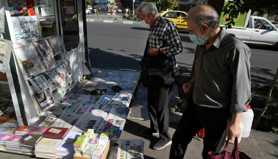 HYLLES: Iranere kikker på aviser i hovedstaden Teheran lørdag. Flere iranske aviser hyller angrepet på Salman Rushdie. Iranere kikker på aviser i hovedstaden Teheran lørdag. Flere iranske aviser hyller angrepet på Salman Rushdie. Foto: Vahid Salemi / AP / NTB