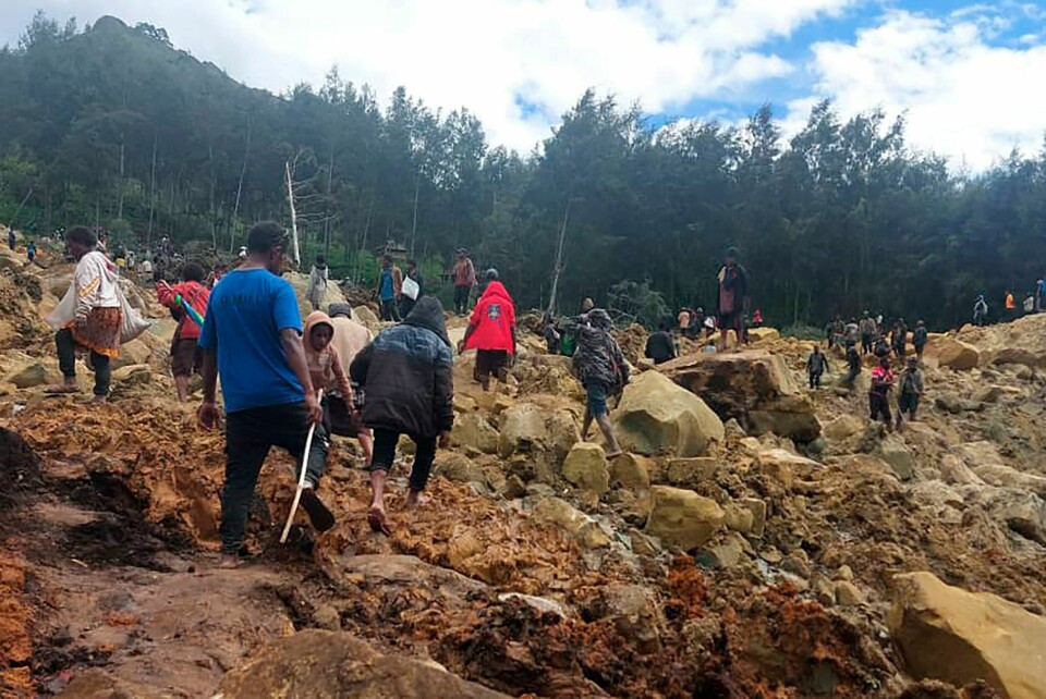 Folk på vei over skredet som kan ha kostet flere hundre mennesker livet i høylandet i Papua Ny-Guinea. Foto: Benjamin Sipa / International Organization for Migration / AP / NTB Folk på vei over skredet som kan ha kostet flere hundre mennesker livet i høylandet i Papua Ny-Guinea. Foto: Benjamin Sipa / International Organization for Migration / AP / NTB