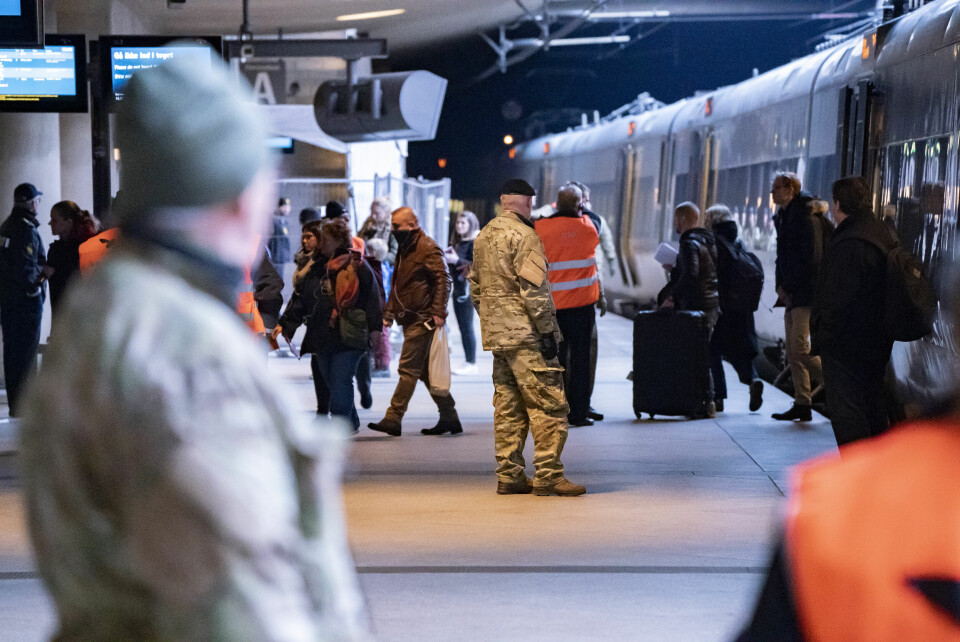 Det danske forsvaret og DSB passer på at passasjerer slippes ut i grupper fra Öresundstogene på stasjonen på Kastrup flyplass søndag. Danmark stengte grensen ved 12-tiden lørdag i et forsøk på å forhindre spredning av koronavirus Foto: Johan Nilsson/TT Nyhetsbyrån / NTB scanpix