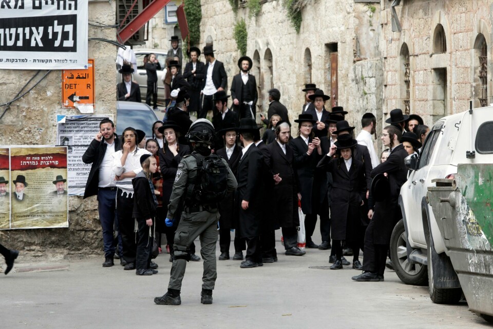 Ultraortodokse jøder samler seg under en markering mot regjeringens tiltak for å stoppe spredningen av koronaviruset i det jødiske ortodokse nabolaget Mea Shearim i Jerusalem mandag 30. mars. Ultra Orthodox Jews gather during a protest against government's measures to stop the spread of the coronavirus in the orthodox neighborhood of Mea Shearim in Jerusalem, Monday, March 30, 2020. (AP Photo/Mahmoud Illean)