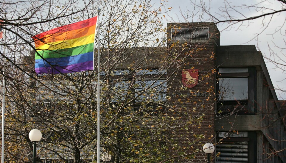 Nå kan man offisielt få heise Pride-flagget mens det foregår lokale arrangementer, melder avisen Norge IDAG. Flaggloven er endret for å gjøre dette mulig. Regnbueflagget har allerede vaiet foran offentlige bygninger der det har foregått Pride-arrangementer. Nå er det flertall på Stortinget for å gi utvidet adgang til slik flagging. Her er Pride-flagget heist opp utenfor kommunehuset i Moss. Arkivfoto: Ørn Borgen / NTB