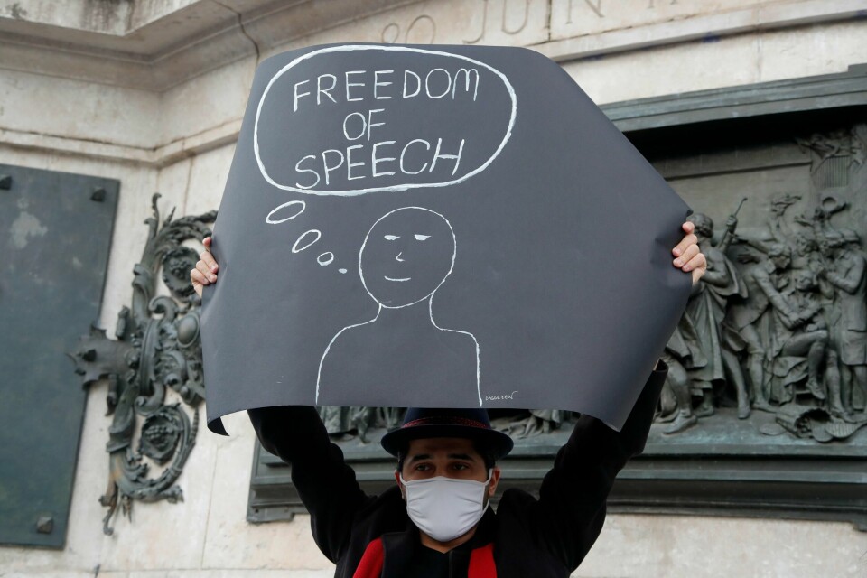 En fransk demonstrant holder opp en plakat med teksten «Ytringsfrihet» etter at læreren Samuel Paty ble drept. Utdanningsforbundet frykter at norske lærere kan bli redd for å ta opp Muhammedkarikaturene i undervisning. (AP Photo/Michel Euler).