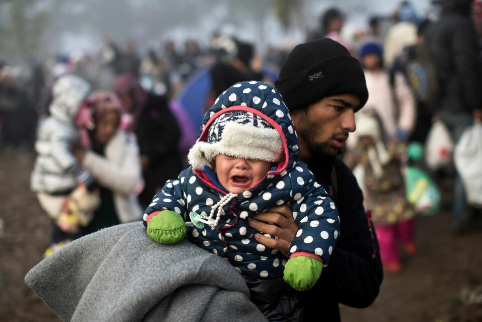 Et flyktningbarn gråter på farens skuldre. Bildet er tatt på grensen mellom Kroatia og Serbia i 2015. Foto: Marko Drobnjakovic / AP foto