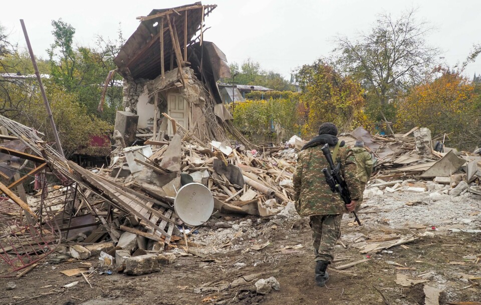 En armensk soldat foran et hus ødelagt av aserbajdsjanske styrker i Stepanakert i Nagorno-Karabakh.