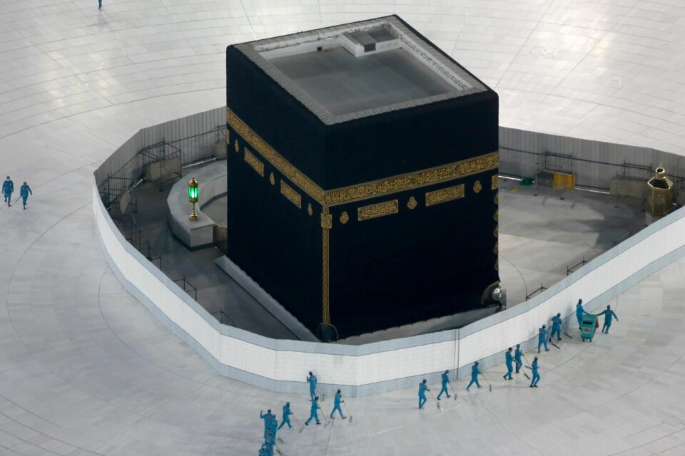 Arbeidere desinfiserer området rundt Kaaba, kuben i den muslimske hellige byen Mekka i Saudia-Arabia.
