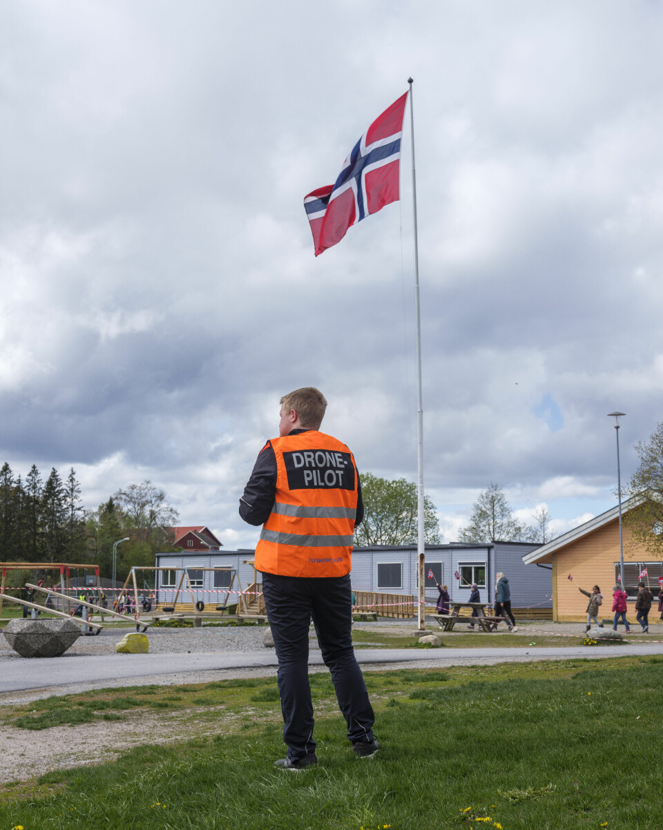 I skolegården står den innleide dronepiloten Anders Frogner Jacobsen, som er på plass for å filme feiringen. – Får du med flagget? spør rektor Ørnø. – Å jada, svarer dronepiloten.