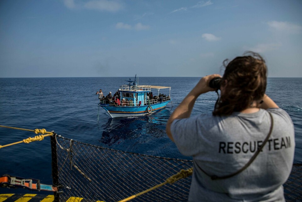 A rescue worker looks though binoculars towards a boat as it sails close to the Open Arms aid boat on Sunday June 30, 2019. A Spanish humanitarian group says its rescue ship spotted 40 dehydrated migrants at sea and their boat is now being escorted to the tiny Italian island of Lampedusa. Proactiva Open Arms spokeswoman Laura Lanuza told The Associated Press that three pregnant women and four children are among the passengers on the boat being escorted by Italy's coast guard Sunday. (AP Photo/Olmo Calvo)