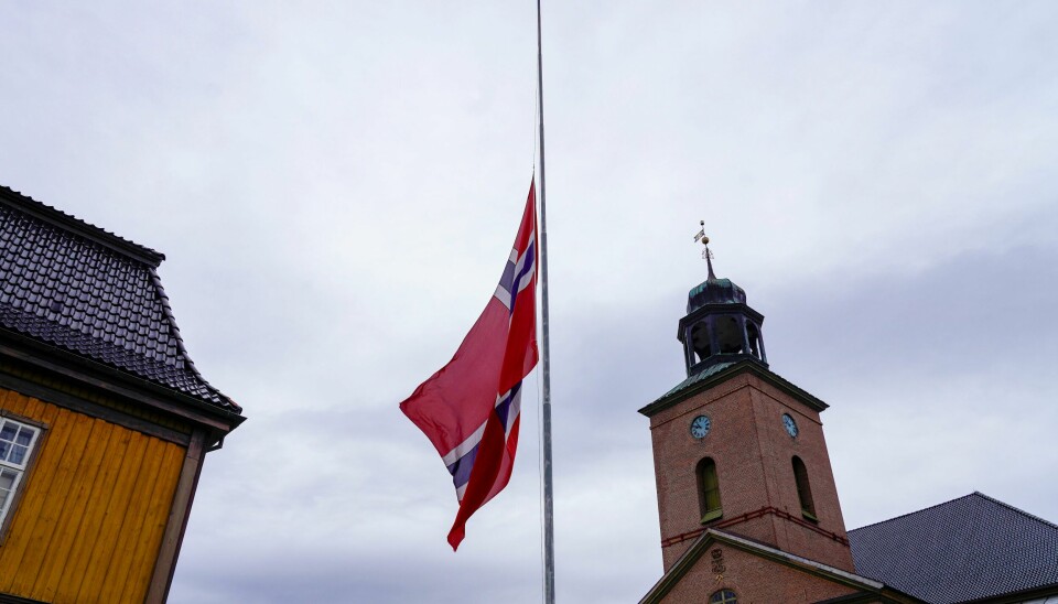 Søndag er det sørgegudstjeneste i Kongsberg kirke etter angrepet i Kongsberg onsdag. Foto: Terje Bendiksby / NTB Flaggene er firt på halv stang rundt om i byen, her ved Kongsberg kirke. Foto: Terje Bendiksby / NTB
