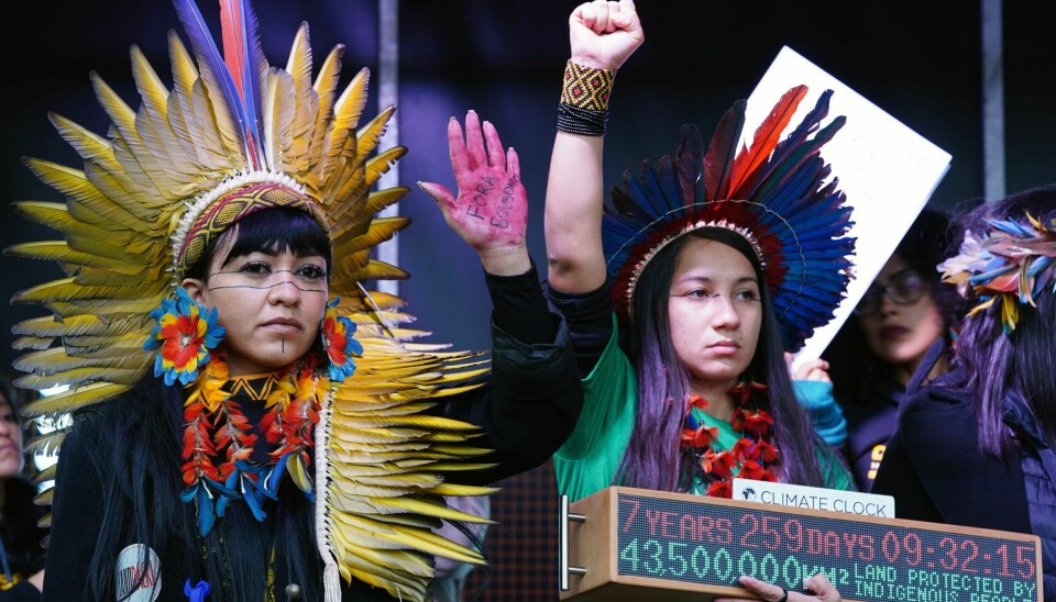 DEMONSTRERER: Urbefolkning fra Brasil taler på George Square i Glasgow under klimatoppmøtet. Indigenous people from Brazil speak on the stage in George Square as part of the Fridays for Future Scotland march during the Cop26 summit in Glasgow, Scotland, Friday, Nov. 5, 2021. The protest was taking place as leaders and activists from around the world were gathering in Scotland's biggest city for the U.N. climate summit, to lay out their vision for addressing the common challenge of global warming. (Jane Barlow/PA via AP)