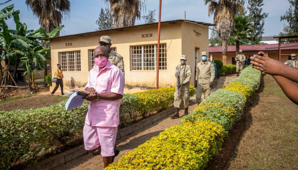 TILTALT: Paul Rusesabagina, iført rosa fangedrakt, på vei til rettslokalene i Kigali i september 2020. Rusesabagina har avvist at han har støttet noen form for voldelige aksjoner og drap. (AP Photo/Muhizi Olivier)