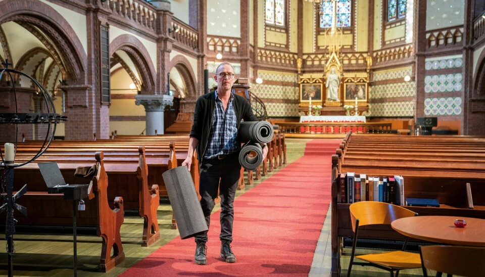 Sokneprest Arne Jor i Paulus og Sofienberg menighet med liggeunderlag under armen. De deles ut til besøkende som ønsker å overnatte i Paulus kirke. På grunn av koronautbruddet er tilbudet nå utsatt på ubestemt tid.