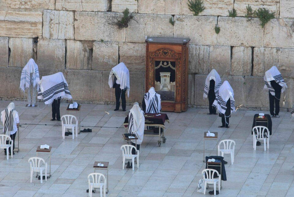 Israeli ultra-Orthodox Jewish men participate in the Cohanim priestly caste blessing during the Jewish holiday of Passover at the Western Wall, the holiest site where Jews can pray in Jerusalem's old city, Sunday, April 12, 2020. The Israeli government approved a tight quarantine of several areas of Jerusalem on Sunday, including the historic Old City, in a bid to slow the spread of the coronavirus in the city's most susceptible neighborhoods. (AP Photo/Sebastian Scheiner)