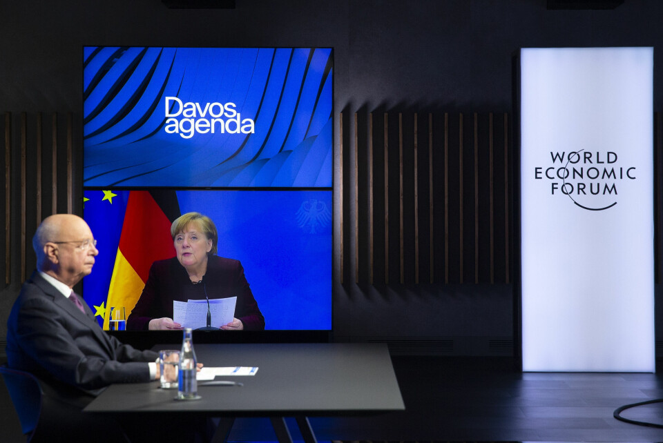DELTAKERE: Klaus Schwab, grunnlegger av World Economic Forum, lytter til Tysklands forbundskansler Angela Merkel konferansen Davos Agenda denne uka. Konferansen pågår fra 25. - 29. januar og er digital på grunn av koronapandemien. German Klaus Schwab, left, Founder and Executive Chairman of the World Economic Forum, WEF, listens to German Chancellor Angela Merkel, displayed on a video screen, during a conference at the Davos Agenda in Cologny near Geneva, Switzerland, Tuesday, Jan. 26, 2021. The Davos Agenda from Jan. 25 to Jan. 29, 2021 is an online edition due to the coronavirus disease (COVID-19) outbreak. (Salvatore Di Nolfi/Keystone via AP)