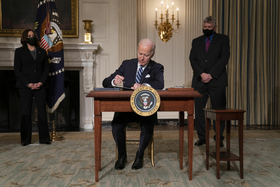 SIGNERER: USAs president Joe Biden signerte onsdag en rekke presidentordre om ny klimapolitikk. Vice President Kamala Harris, left, and White House science adviser Dr. Eric Lander, right, look on as President Joe Biden signs a series of executive orders on climate change, in the State Dining Room of the White House, Wednesday, Jan. 27, 2021, in Washington. (AP Photo/Evan Vucci)